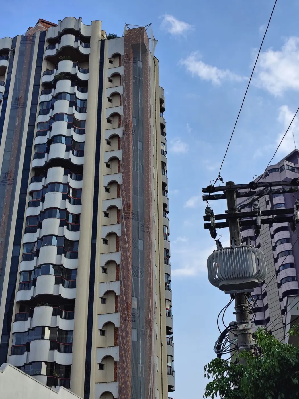 Obra da JK: fachada de edifício de múltiplos pavimentos com sistema de proteção